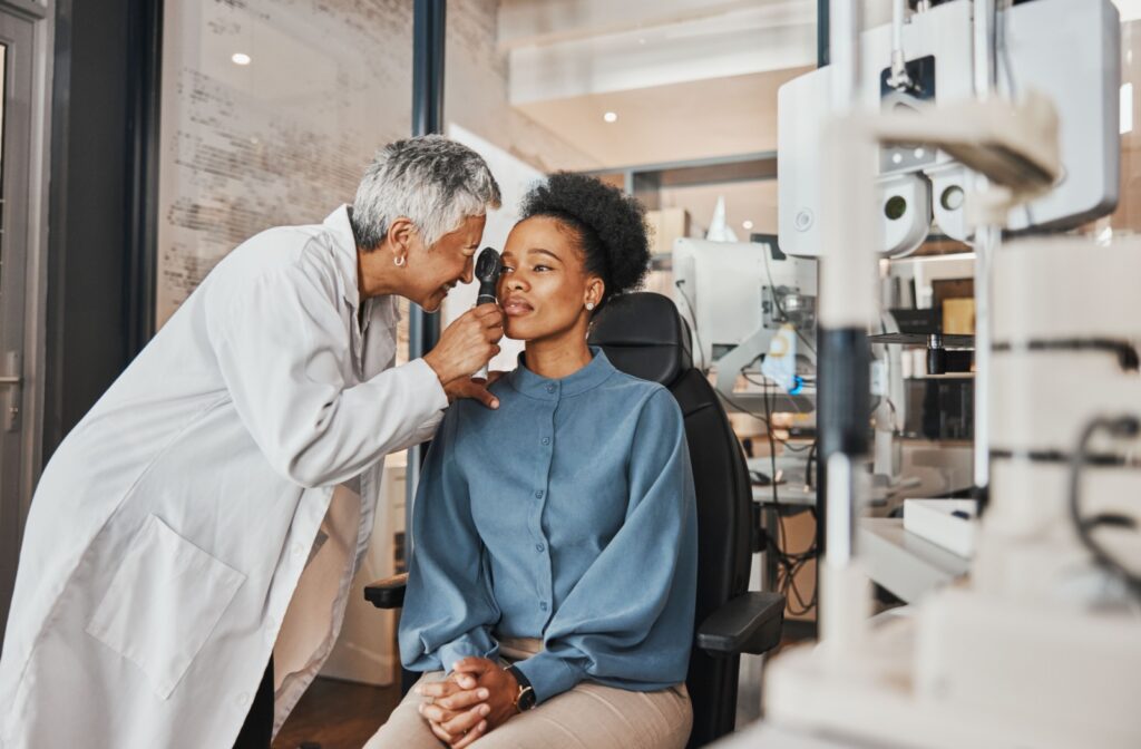 An optometrist uses an opthamalscope to examine the internal structures of their patient's eye.