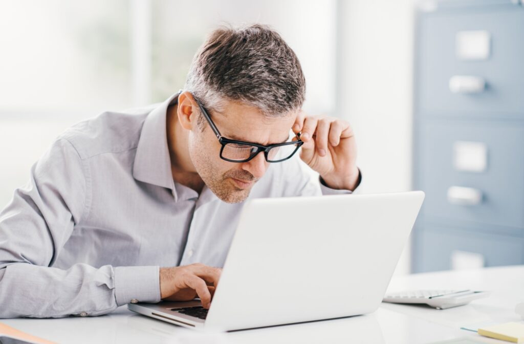 Person with age-related macular degeneration (AMD) struggling to see laptop screen.